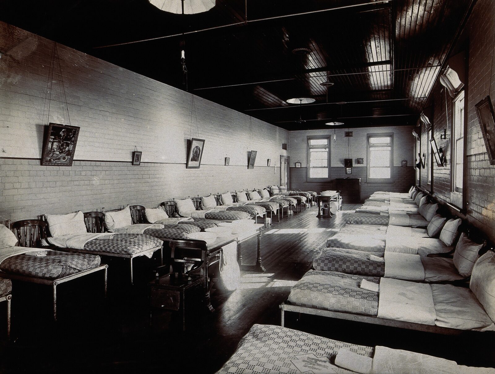 A women's ward in 1894: two long rows of iron beds in a brick-walled dormitory